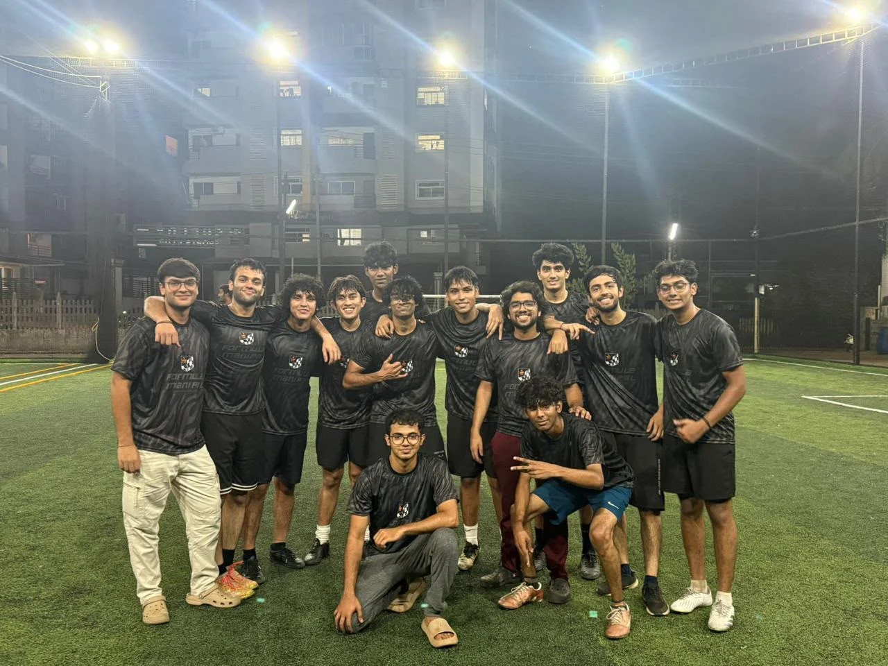 Football team together on a pitch wearing custom black jerseys